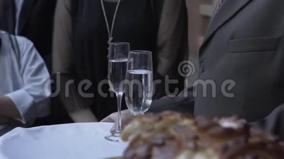 一位老人拿着香槟酒杯在托盘上视频的预览图