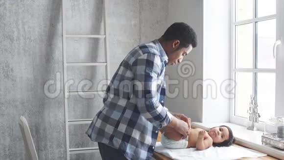 男人在家里照顾他可爱的小孩子视频的预览图
