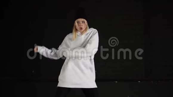 慢动作的女孩跳嘻哈在白色的衣服在黑色的房间视频的预览图