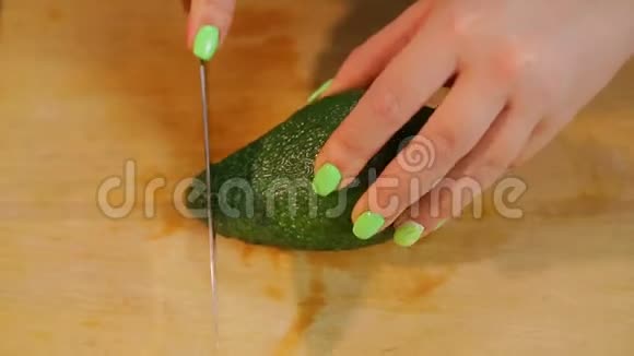 女用手在木板上用刀清洗鳄梨水果视频的预览图