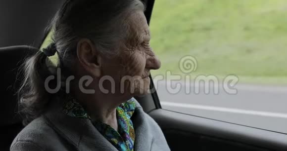 一位皱纹很深的祖母坐在车里望着窗外视频的预览图