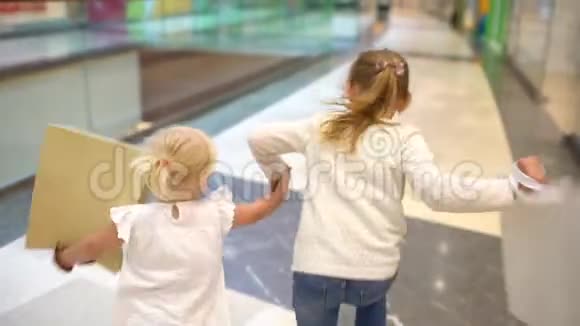 现代家庭的购物日带着包裹的小女孩和家人一起在大购物中心散步儿童视频的预览图