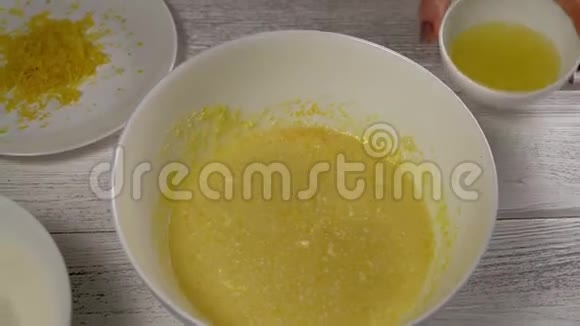 女的手特写从碗里倒出柠檬汁把柠檬口味放进碗里里面有烹饪原料视频的预览图