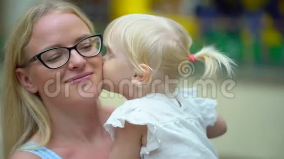 现代家庭的购物日美丽的母亲和她的小女儿在室内亲吻拥抱幸福的家庭视频的预览图