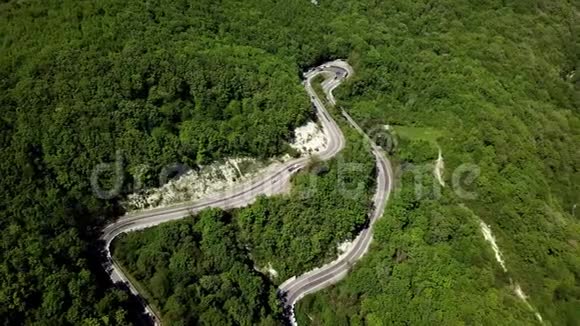 用汽车和卡车在山间蜿蜒曲折的道路上鸟瞰视频的预览图