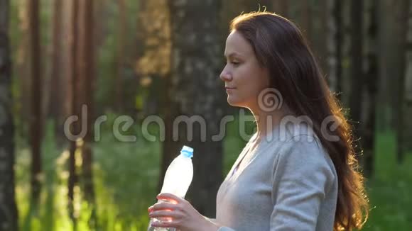 女人在公园喝淡水慢动作视频的预览图