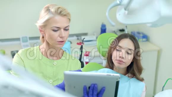 女性牙医使用平板电脑显示病人治疗计划的牙医视频的预览图