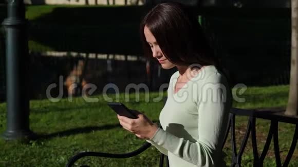 阳光明媚的女人面对智能手机视频的预览图