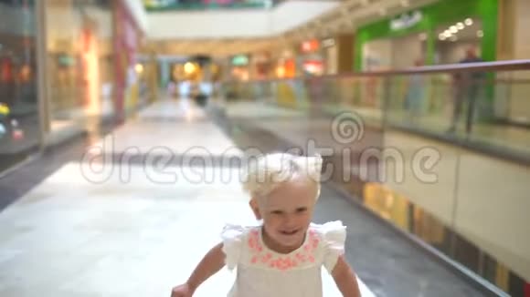 现代家庭的购物日带着包裹的小女孩和家人一起在大购物中心散步视频的预览图