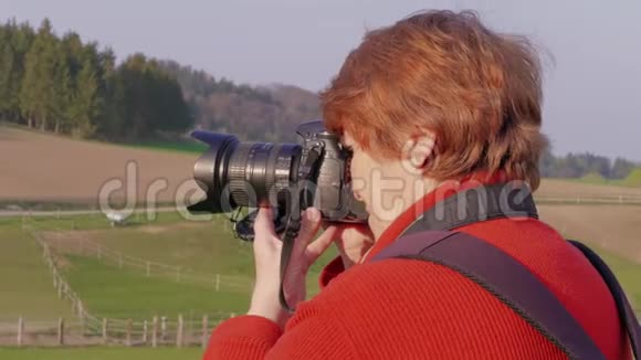 资深女士拍摄数码单反相机游客聚焦视频的预览图