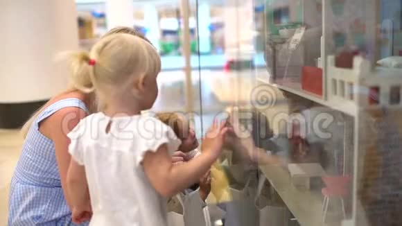 现代家庭的购物日小女孩在她想要礼物的玩具上表演一个金发的小孩子视频的预览图