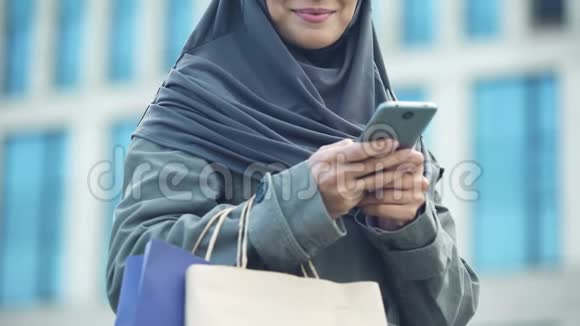 成功购物后微笑着在户外聊天的阿拉伯女士视频的预览图