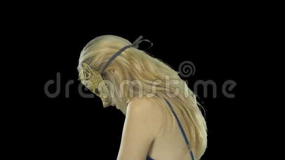 一个身穿威尼斯金色面具和晚礼服的金发女人带着神秘的神情转过身然后微笑着期待着视频的预览图