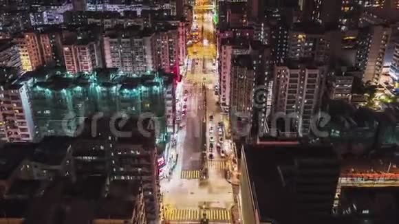 在香港市中心地区汽车交通和夜间行走的人的超移时无人驾驶飞机俯视视频的预览图