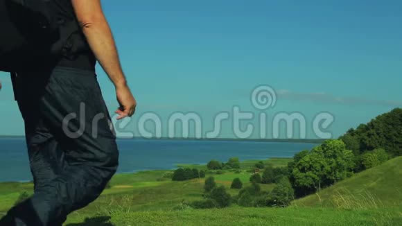一男一女背着背包走近山边欣赏下面的湖面视频的预览图