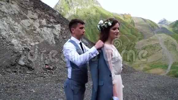 新郎温柔的打扮新娘的夹克而她亲切的微笑波霍婚礼户外婚礼视频的预览图