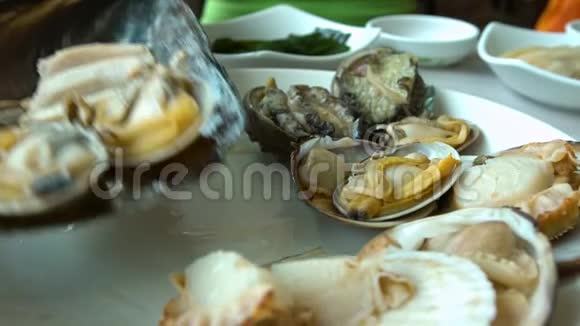 4在釜山贾加尔奇鱼市的韩国餐馆提供新鲜蛤蜊浓汤视频的预览图