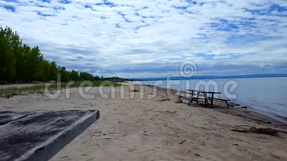 沿着美丽的沙滩海滨野餐桌夏日阳光假期海滨海滩目的地与美丽的天空视频的预览图