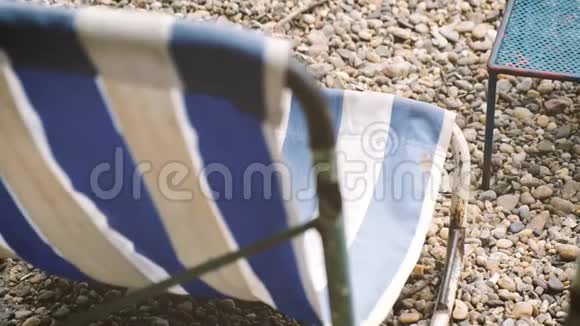 甲板椅被风吹到卵石滩上视频的预览图