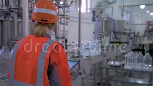 繁重的女性工作工厂的专家女孩戴着安全帽用电脑平板电脑修改和控制硬件视频的预览图