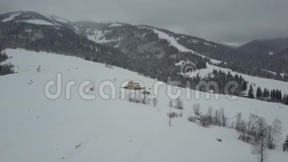 飞越喀尔巴阡山的一个村庄鸟山上白雪覆盖的房子的视野乡村景观视频的预览图
