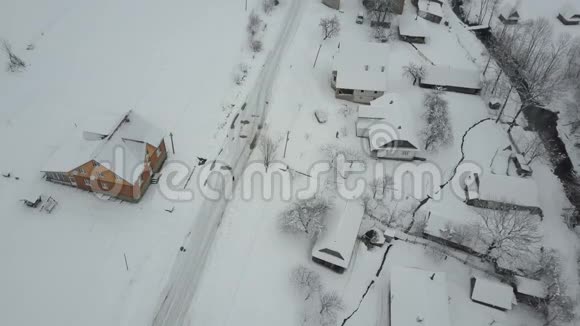 在喀尔巴阡村的冬季公路上行驶的一辆汽车上快速飞行鸟雪覆盖的房子的视野农村视频的预览图
