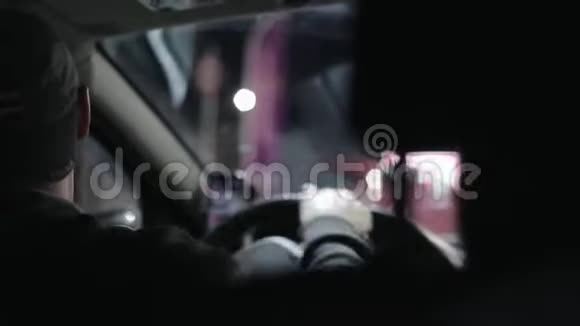 一个戴着帽子的微笑的男司机向后转弯晚上开车背面视频的预览图