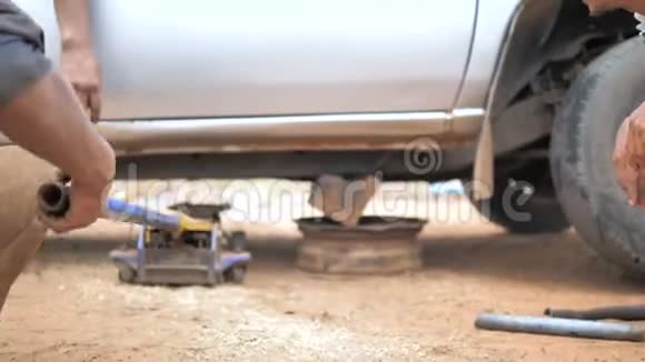 机械师用汽车千斤顶抬起卡车来修理托骨控制臂更换汽车的前轮视频的预览图