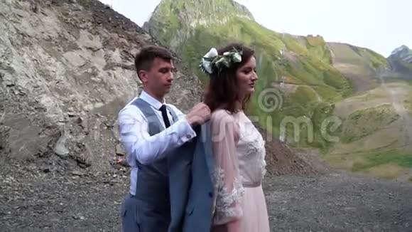 新郎温柔的打扮新娘的夹克而她亲切的微笑波霍婚礼户外婚礼视频的预览图