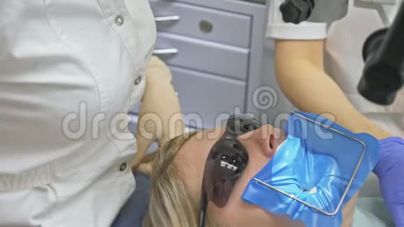 牙科诊所的医疗保健牙医和医疗助理的工作人员检查女性客户的卫生视频的预览图
