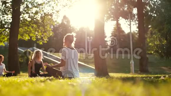 夏季阳光明媚的早晨一群妇女在公园里慢动作练习冥想视频的预览图