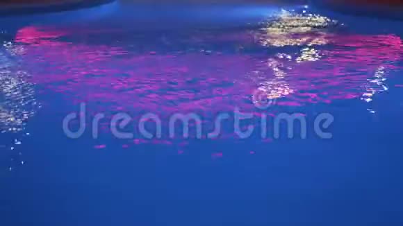 游泳池有夜间照明这改变了颜色室外游泳池有冷水有照明的夜间游泳池视频的预览图