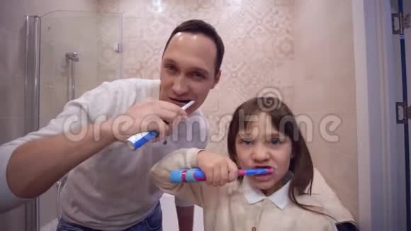 口腔健康快乐爸爸带着孩子在镜子前刷牙视频的预览图