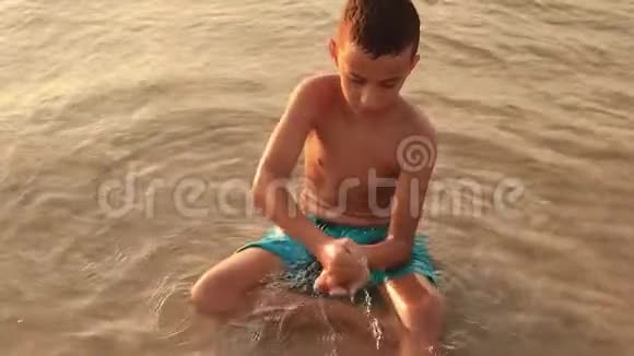 海沙穿过男孩的手男孩手中的沙子视频的预览图