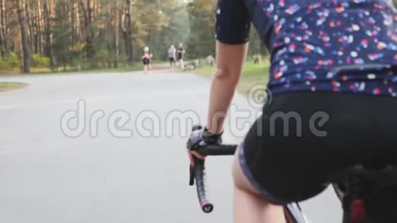 女三项运动员骑自行车女孩在公园骑自行车关闭踏板的运动铁人三项的概念慢动作视频的预览图
