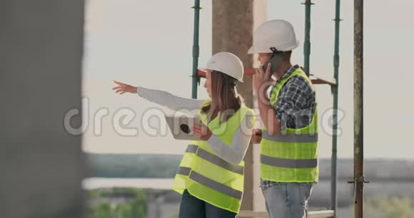 一名女工程师和一名男工程师用平板电脑和手机对建筑进行可视化视频的预览图