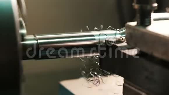 转动车床在动作切割机在缓慢的运动中从钢坯中移除金属刨花特写金属加工视频的预览图