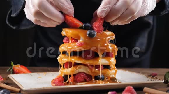 烹饪理念厨师手把森林浆果放在美味的有机煎饼上在家吃早餐视频的预览图