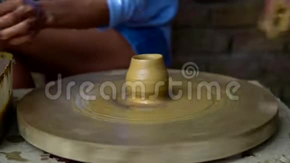 老陶工引导女士用手指在轮子上做陶罐视频的预览图