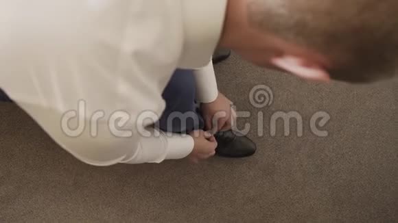 男人在系他的黑鞋特写新娘女孩把他的鞋子绑在黑白的一个未来的丈夫为了一个视频的预览图
