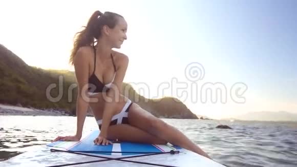 海浪拍板女孩用脚踩水视频的预览图