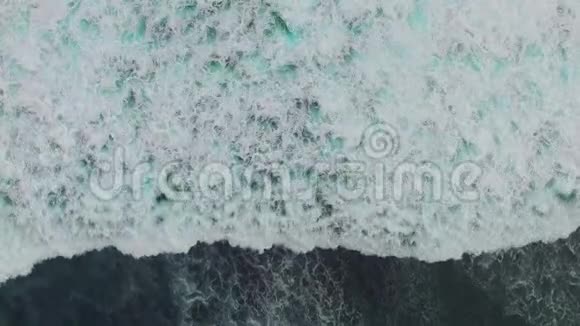 海洋蓝波撞击海岸线无人机镜头的俯视图视频的预览图