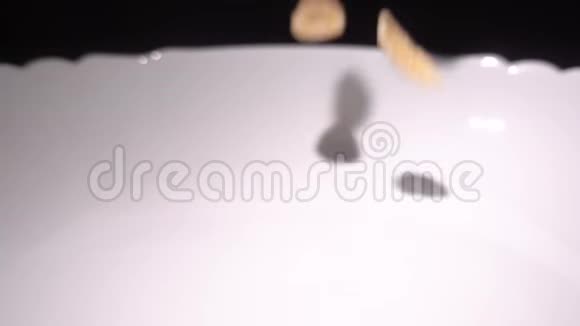 超级慢动作玉米片掉进牛奶碗顶景视频的预览图
