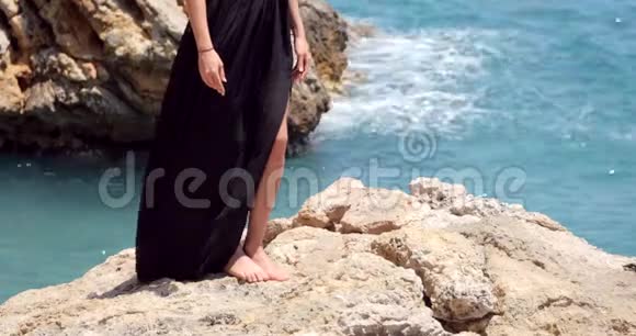 美丽的女人在海边穿着优雅的黑色长裙视频的预览图