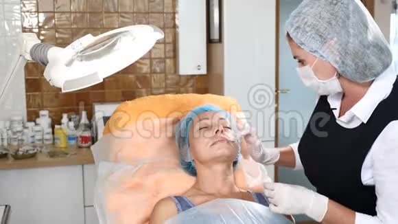 美容师在保健诊所应用麻醉前面部手术老年妇女接受美容治疗4k视频的预览图