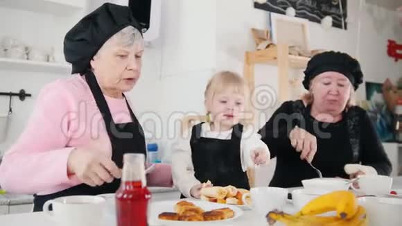 一家人在厨房吃煎饼吃香蕉的小女孩视频的预览图