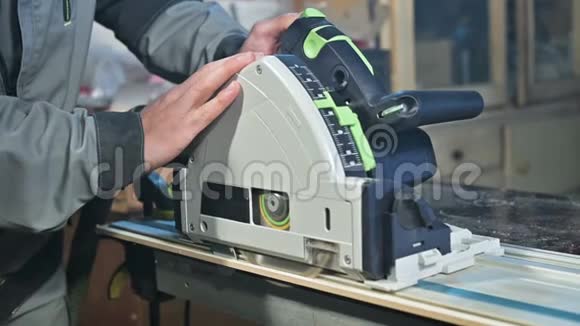 木工在家庭车间用手圆锯加工的手的特写整理木制部件视频的预览图