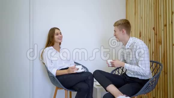 两个高中生正拿着饮料坐在客厅的沙发上聊天视频的预览图