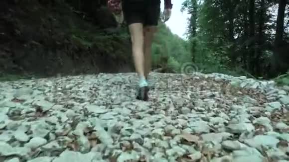 夏天的森林里一个年轻的时髦女孩从鞋子里走到白色的鹅卵石小径上视频的预览图