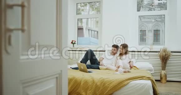 舒适的卧室一对夫妇一起看电影和吃爆米花视频的预览图